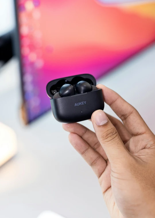 a person holding an apple airpods in their hand, a digital rendering, trending on pexels, new objectivity, shot with sony alpha, black resin, everything fits on the screen, back towards camera