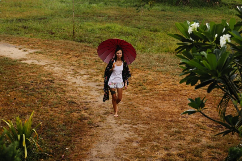 a woman walking down a dirt path with an umbrella, in style of thawan duchanee, avatar image, vacation photo, profile image