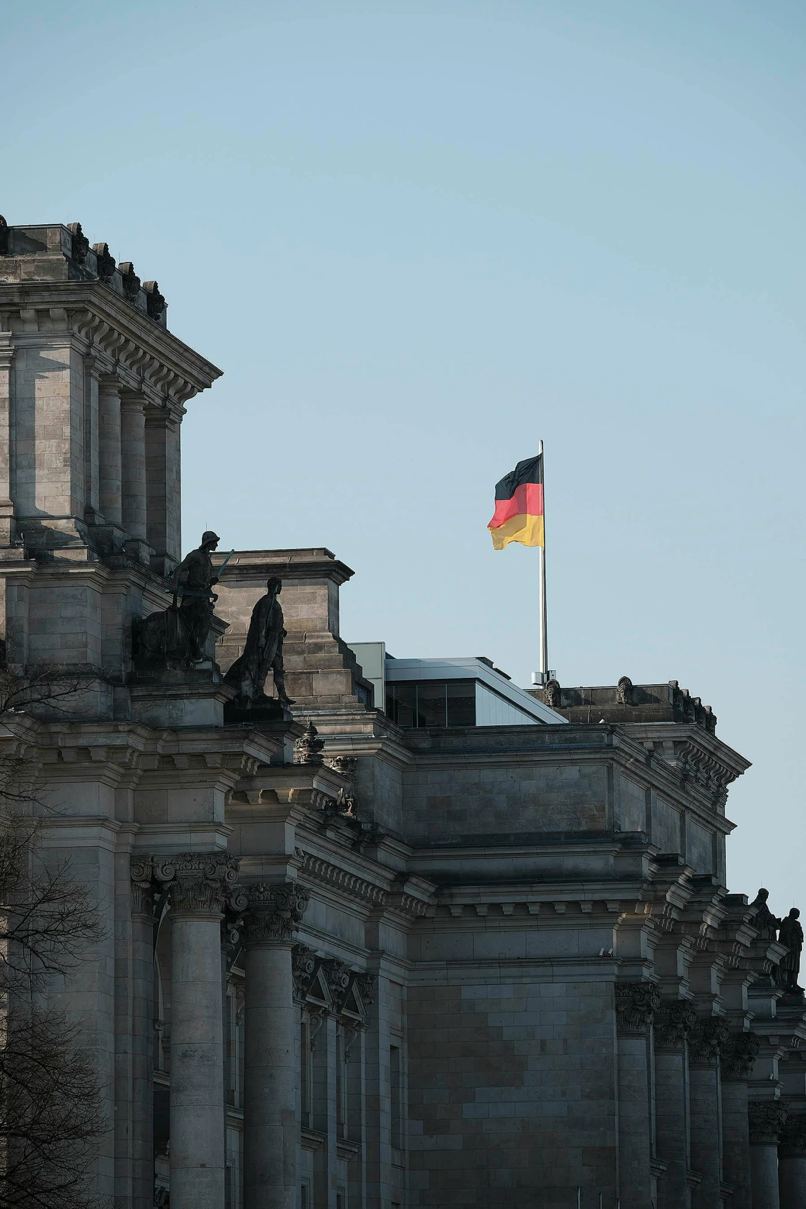 a building with a flag on top of it, unsplash, berlin secession, profile image, german chancellor, square, tall stone spires