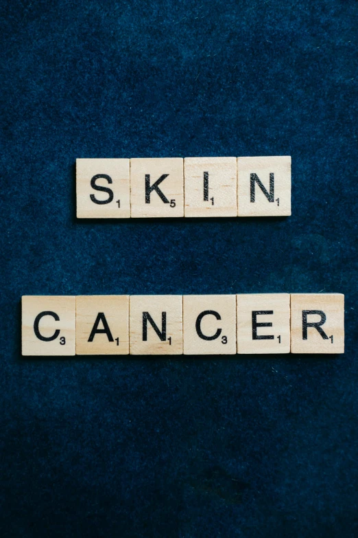 scrabbles spelling skin cancer on a blue background, an album cover, shutterstock, charcoal skin, dirty skin, trending on, on a dark background