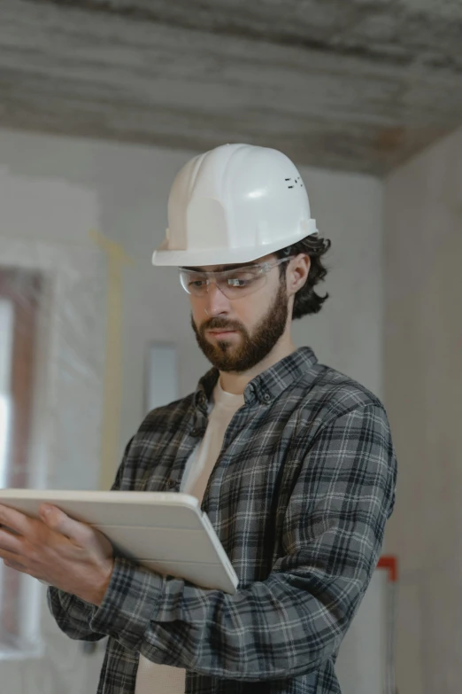 a man in a hard hat holding a tablet computer, pexels contest winner, lgbtq, instagram post, looking serious, plaster