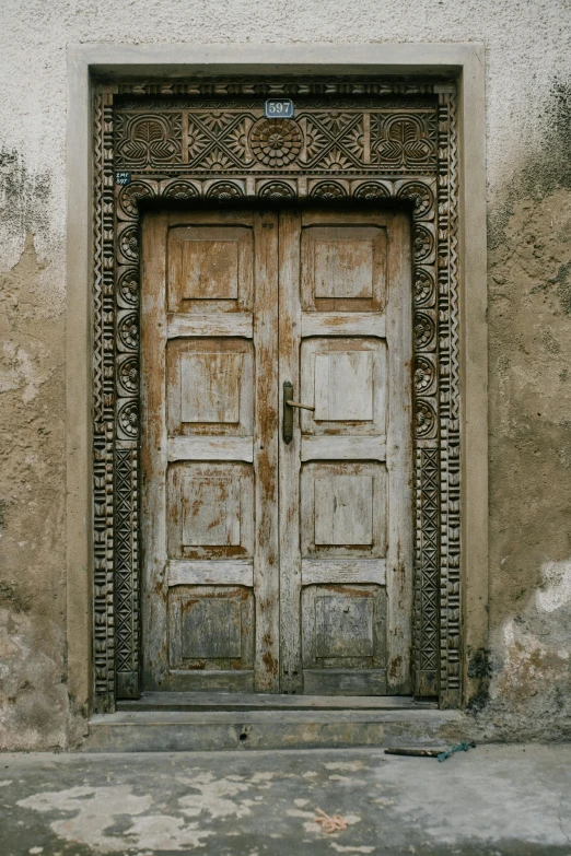 an old wooden door on the side of a building, by Jordan Grimmer, renaissance, afar, a temple, grey