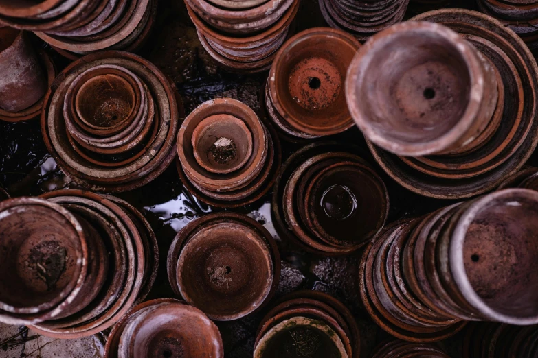 a bunch of brown pots stacked on top of each other, trending on unsplash, environmental art, made from mechanical parts, splash image, top - down photograph, made of glazed