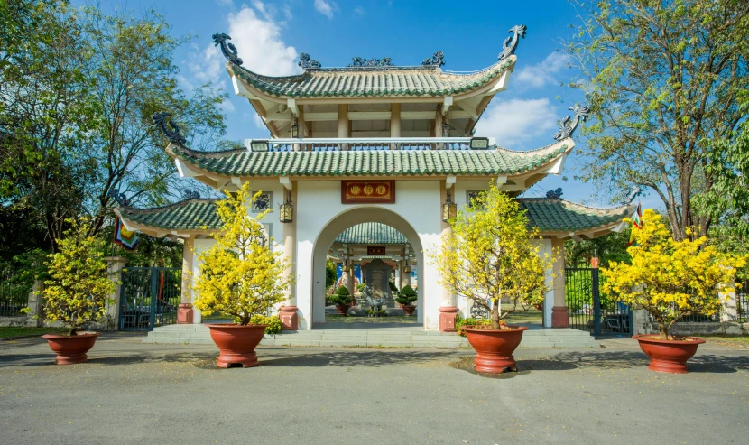 a building with potted plants in front of it, inspired by Cui Bai, trending on unsplash, cloisonnism, vietnamese temple scene, a park, blue sky, square