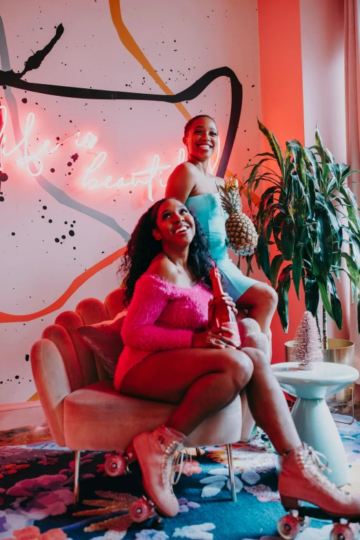 two women sitting on a couch in front of a neon sign, by Dulah Marie Evans, trending on pexels, black arts movement, in a candy land style house, posing together in bra, group photo, twinkling and spiral nubela