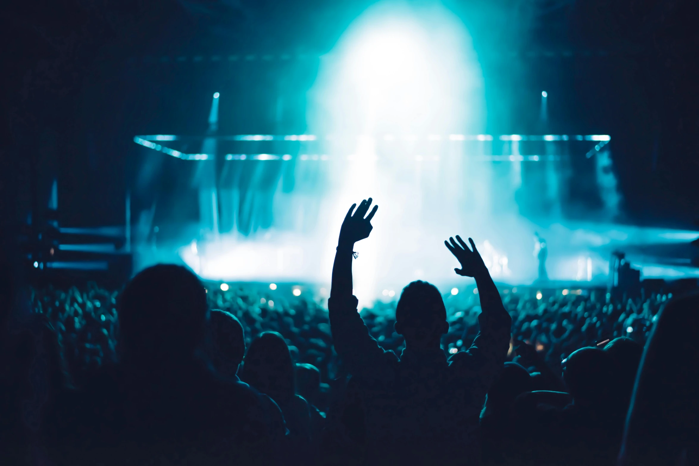 a person raising their hands at a concert, an album cover, pexels contest winner, blue atmosphere, avatar image, dark teal lighting, people watching around