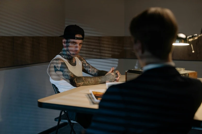 a man sitting at a table in front of a laptop computer, a tattoo, pexels contest winner, hyperrealism, in a meeting room, lil peep, ( ( theatrical ) ), justin gerard and greg rutkowski