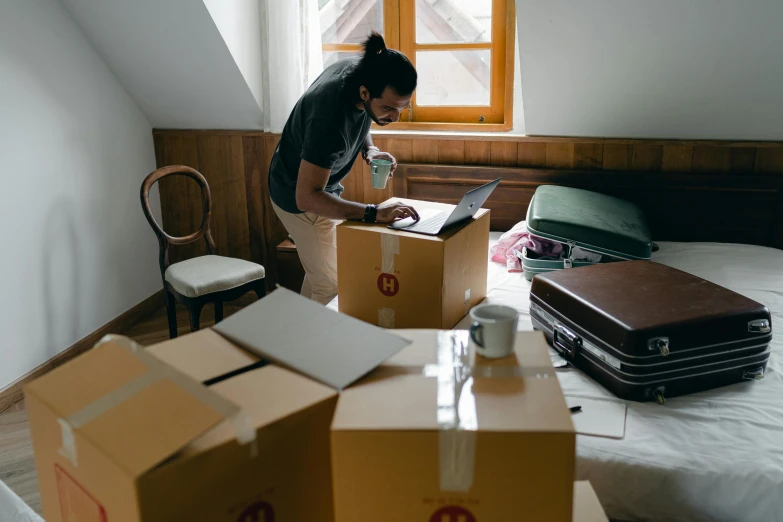 a woman standing next to a pile of boxes on top of a bed, by Matthias Stom, pexels contest winner, working on a laptop at a desk, a handsome, thumbnail, -4