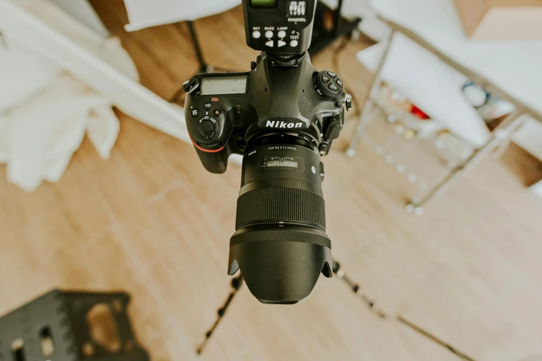 a close up of a camera on a tripod, indoor picture, facing the camera, wide overhead shot, posing elegantly over the camera