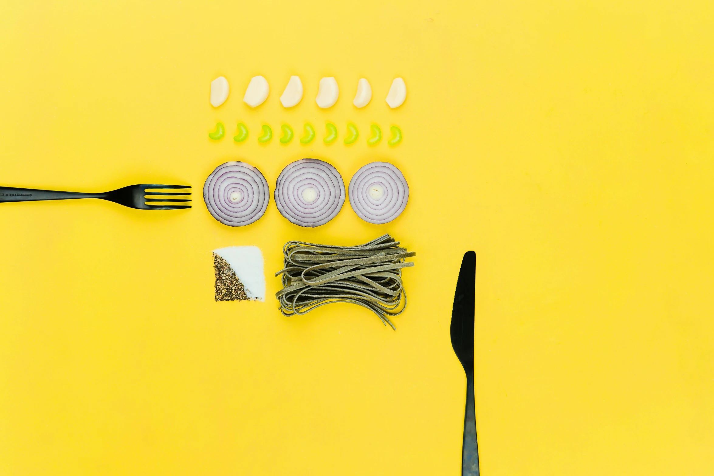 a fork, knife, and onion on a yellow background, by Carey Morris, pexels contest winner, knolling, spaghetti, yellow purple green black, ingredients on the table