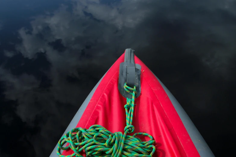 a red boat sitting on top of a body of water, a portrait, hanging rope, black sky, inflatable, detailed product image
