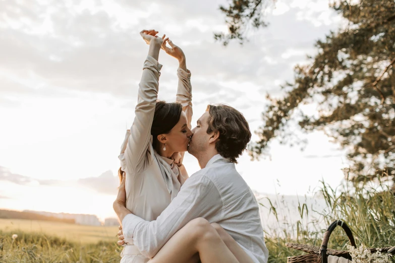 a man and woman sitting next to each other in a field, pexels contest winner, romanticism, making out, having a picnic, white, dancing with each other