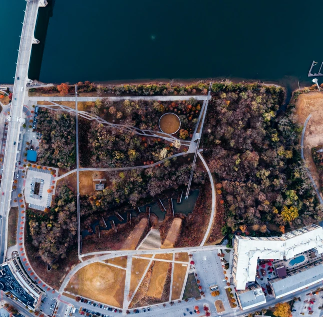 an aerial view of a construction site next to a body of water, pexels contest winner, parks and public space, curved bridge, 1 4 9 3, thumbnail