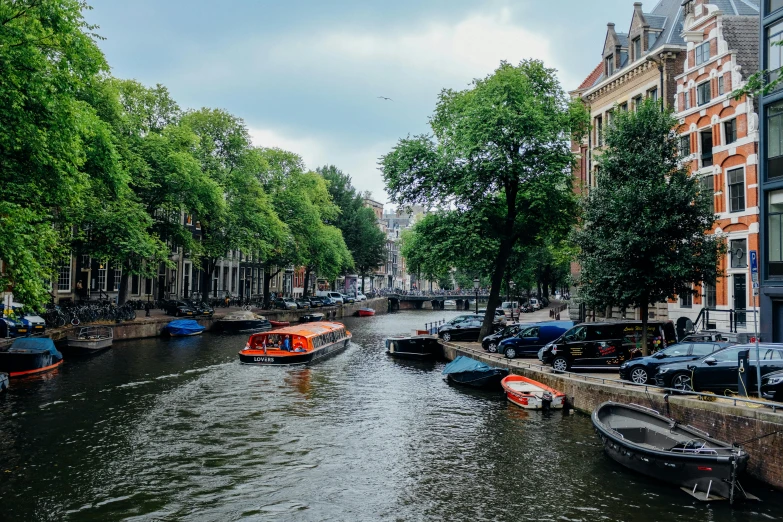 a canal filled with lots of boats next to tall buildings, a photo, by Jan Tengnagel, pexels contest winner, 🦩🪐🐞👩🏻🦳, the city is full of green plants, jan vermeer, with an intricate