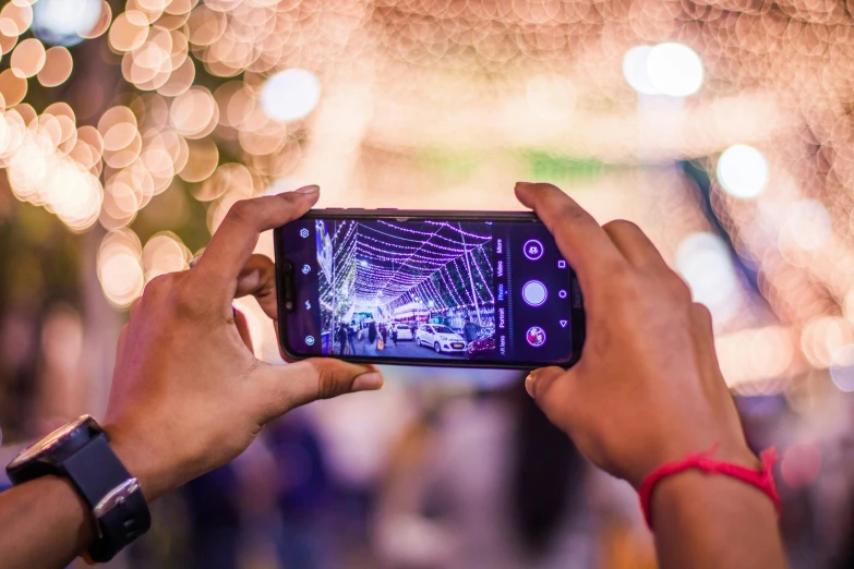 a person taking a picture with a cell phone, by Julia Pishtar, pexels contest winner, dazzling lights, android close to camera, title, rectangle