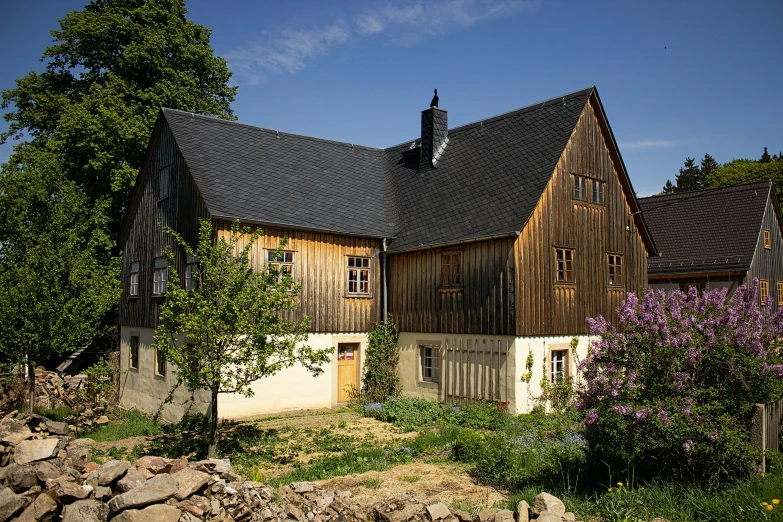 a large wooden house sitting on top of a lush green field, by Jörg Immendorff, unsplash, heidelberg school, barn, slate, portrait image