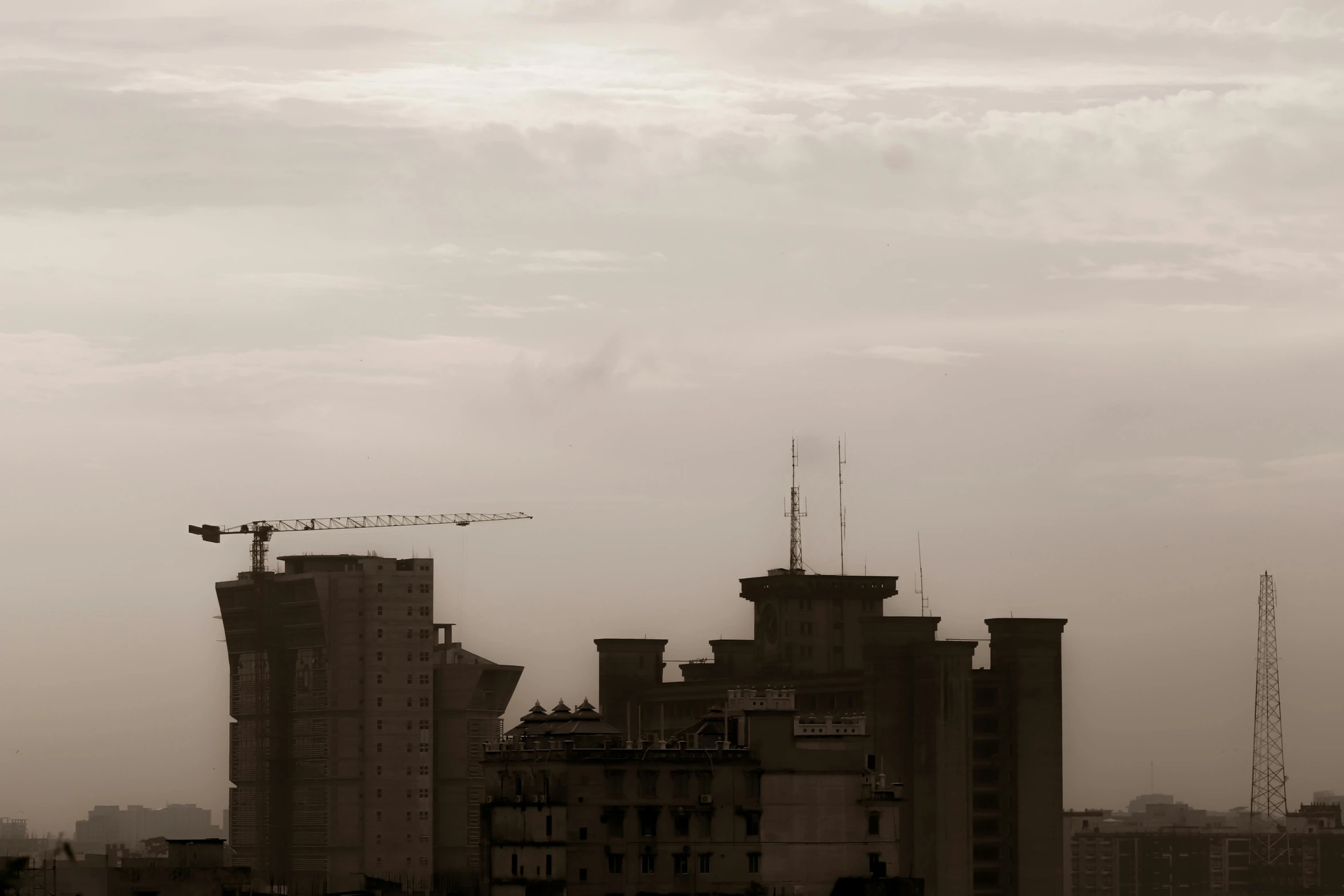 a black and white photo of a city skyline, unsplash, brutalism, sepia colors, talaat harb square cairo, cranes, high quality photo