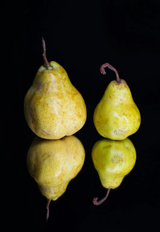 three pears sitting next to each other on a black surface, a still life, by David Garner, unsplash, square, mirrored, potato, made of glazed