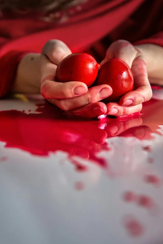 a person holding two red apples in their hands, by Julia Pishtar, pexels contest winner, art photography, paint spill, easter, polish, made of blood