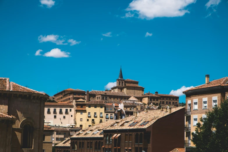 a group of buildings that are next to each other, inspired by Juan Giménez, pexels contest winner, neoclassicism, clear blue skies, teruel city in 1989, rooftop party, youtube thumbnail