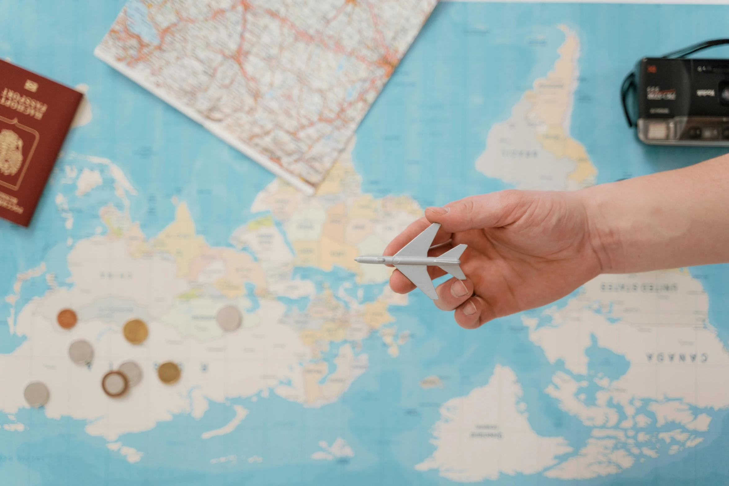 a person holding a paper airplane in front of a map, by Julia Pishtar, pexels contest winner, regionalism, uk, mini model, coastal, dezeen