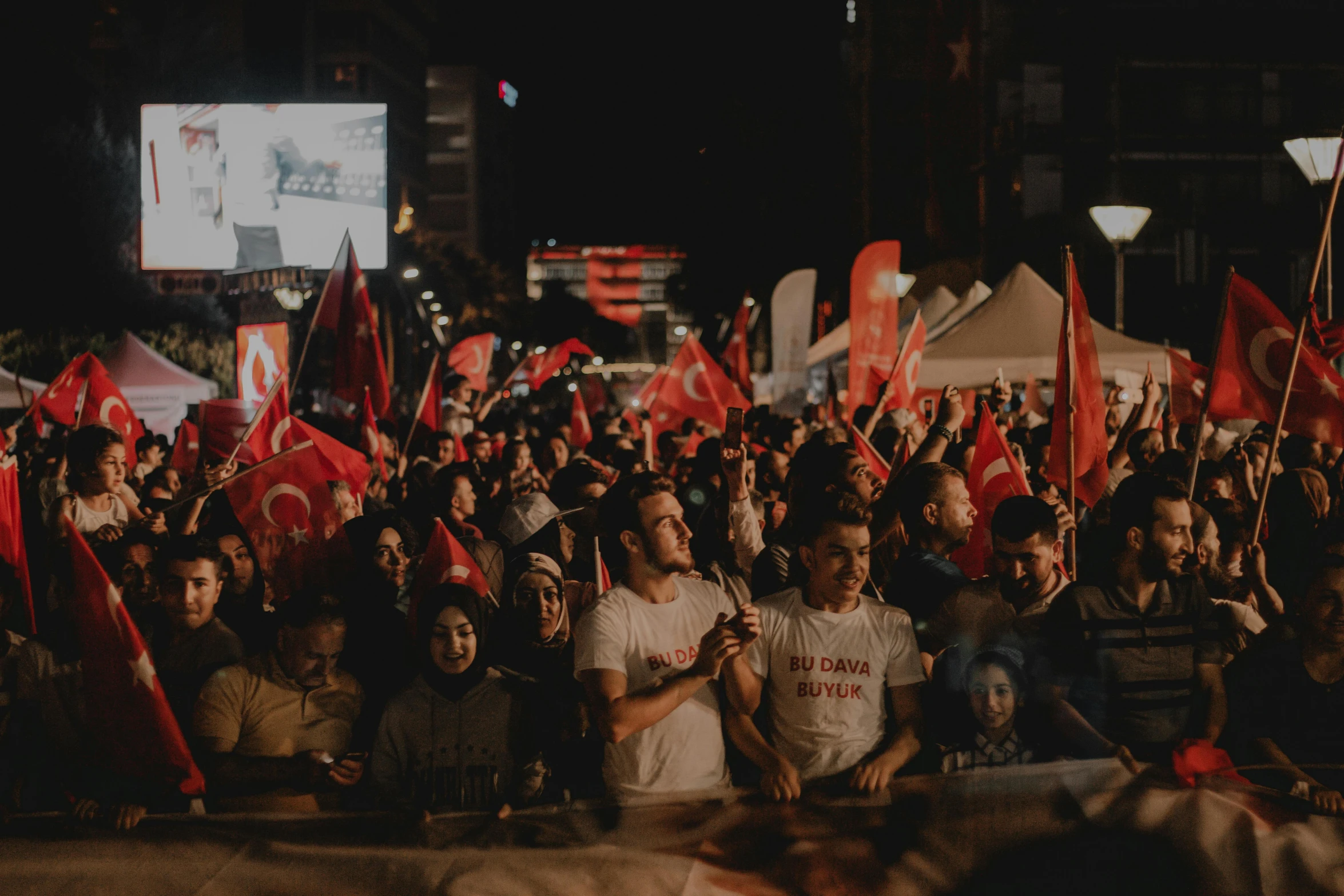 a group of people that are standing in the street, pexels contest winner, hurufiyya, red banners, avatar image, turkey, (night)