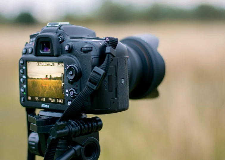 a camera sitting on top of a tripod in a field, a picture, unsplash, nikon d 7 2 0 0, home video footage, timelapse, close up dslr studio photograph