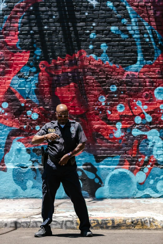 a man standing in front of a graffiti covered wall, officer, dave chappelle, profile image, large)}]