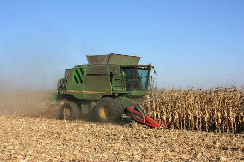 a combine harvester in the middle of a corn field, by Joe Stefanelli, slide show, getty images, reverse