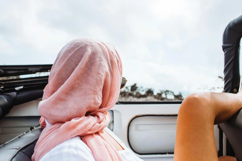 a couple of people that are sitting in the back of a truck, trending on unsplash, head scarf, white and pink cloth, bulli, over the horizon