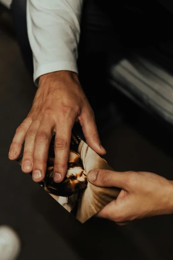 a close up of a person putting a ring on a person's finger, an album cover, by Thomas Wijck, pexels contest winner, holes in a religious man, vinyl material, high angle, inspect in inventory image