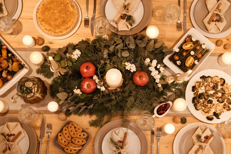 a wooden table topped with plates of food, a digital rendering, pexels, renaissance, evergreen branches, holiday, full-body, long