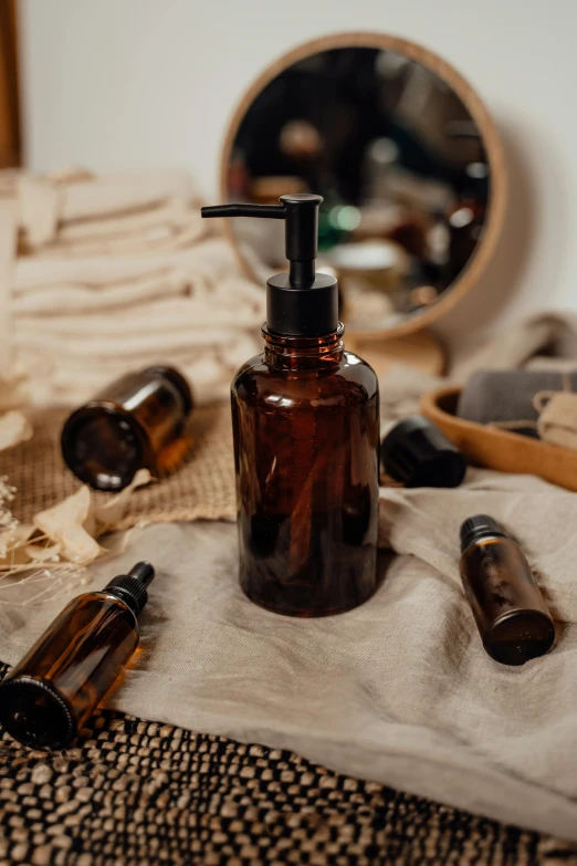 a brown bottle sitting on top of a bed next to a mirror, a still life, trending on pexels, alchemical equipment, soap, full face, profile image