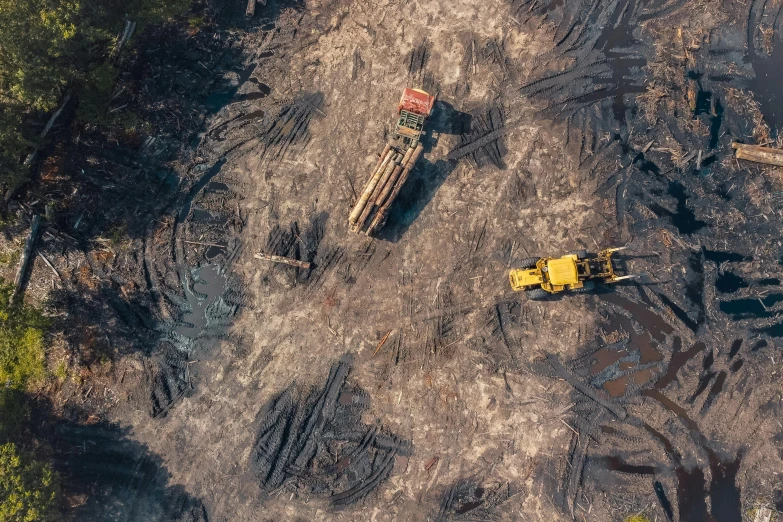 a couple of trucks that are in the dirt, pexels contest winner, smouldering charred timber, helicopter view, thumbnail, gold