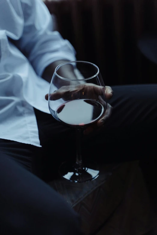 a close up of a person holding a wine glass, inspired by Elsa Bleda, sitting alone, gentleman, after hours, **cinematic