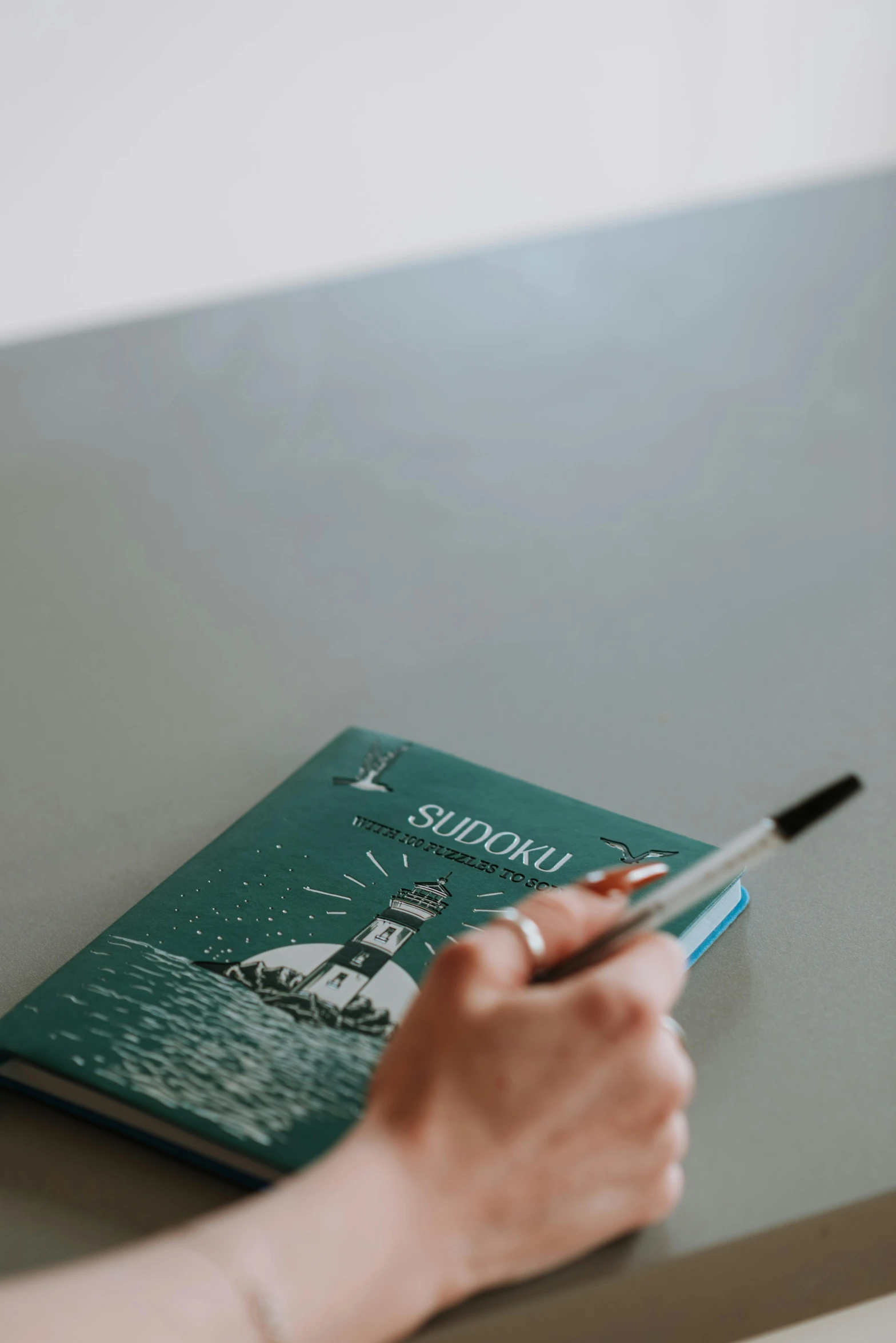 a person writing a book on a table, sea green color theme, swedish writing, shinkai, thumbnail