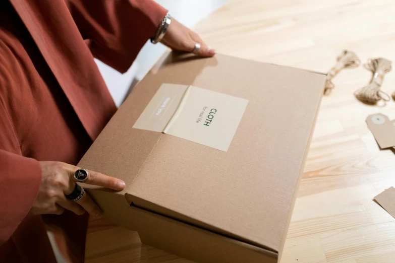 a close up of a person holding a box on a table, order, cosy, very large, thumbnail