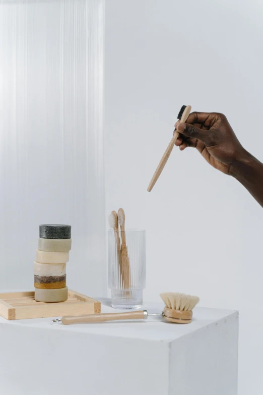 a close up of a person holding a toothbrush, shades of gold display naturally, jars, dwell, modular