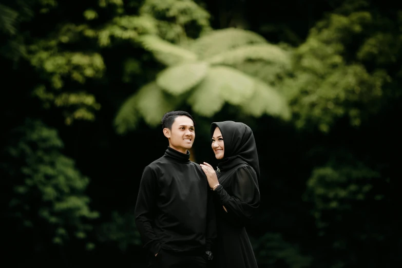 a man and a woman standing next to each other, a picture, by Basuki Abdullah, pexels contest winner, hurufiyya, black and green, foliage clothing, square, avatar image