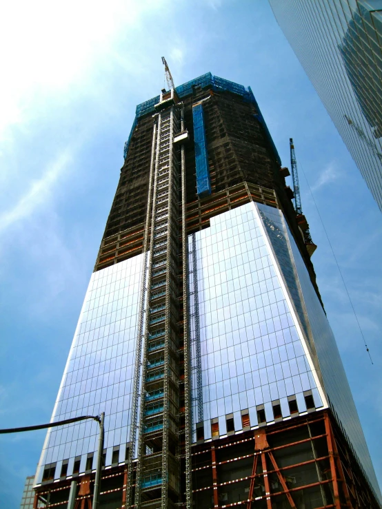 a tall building sitting in the middle of a city, front facing the camera, under construction, 9/11, promo image