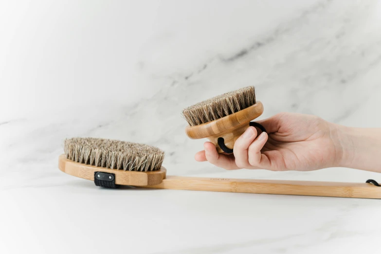 a person brushing their hair with a wooden brush, by Emma Andijewska, unsplash, with seaweed, on textured base; store website, grey, complete body view