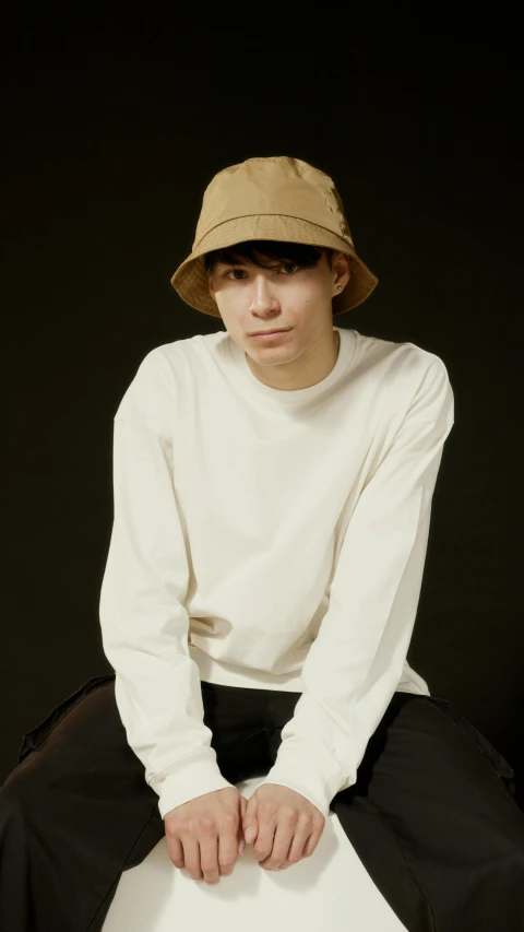 a man sitting on a chair wearing a hat, trending on pexels, portrait of a japanese teen, long sleeves, beige, 8