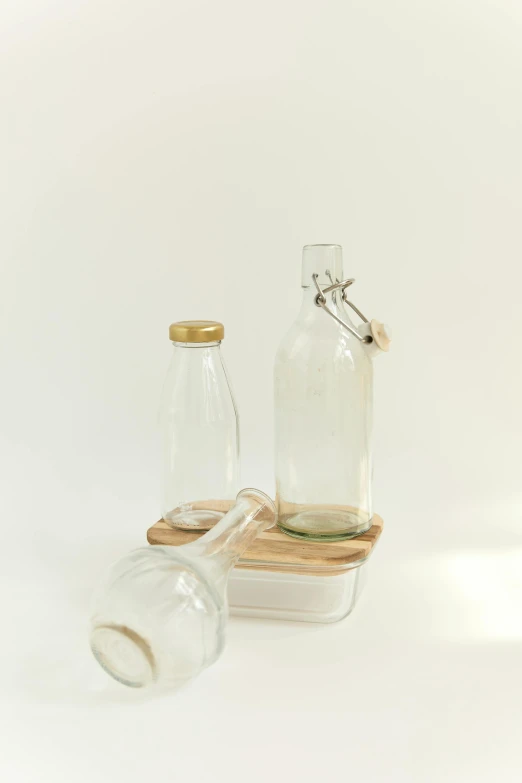 a couple of glass bottles sitting next to each other, natural wood top, basic, recycled, product image