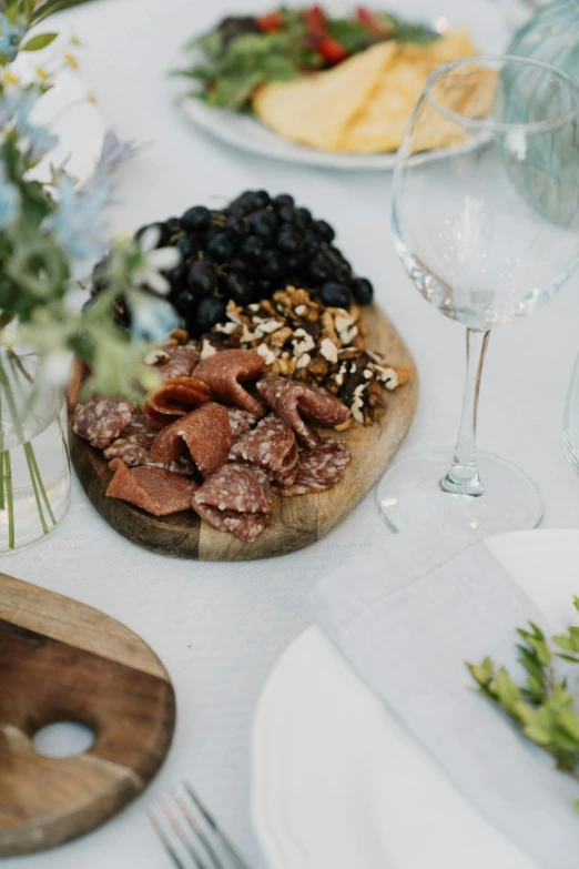 a close up of a plate of food on a table, by Jessie Algie, pexels, cheese and salami on the table, wedding, garden setting, grey