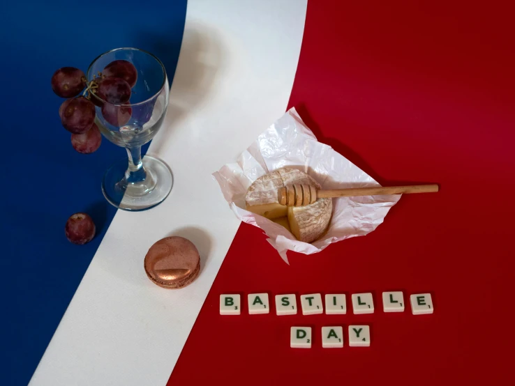 a glass of wine sitting on top of a red, white and blue table, an album cover, inspired by Édouard Detaille, unsplash, de stijl, deconstructed waffle, good day, made of bronze, french flag