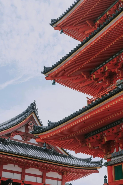 a group of people standing in front of a tall red building, inspired by Itō Jakuchū, trending on unsplash, tiled roofs, view from below, red trusses, square