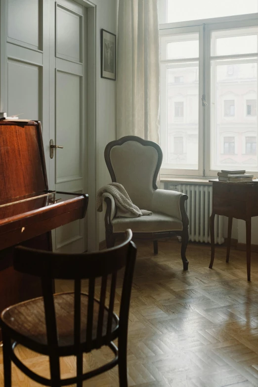 a living room filled with furniture and a piano, inspired by Wilhelm Hammershøi, baroque, city apartment cozy calm, old chairs, warsaw, morning light