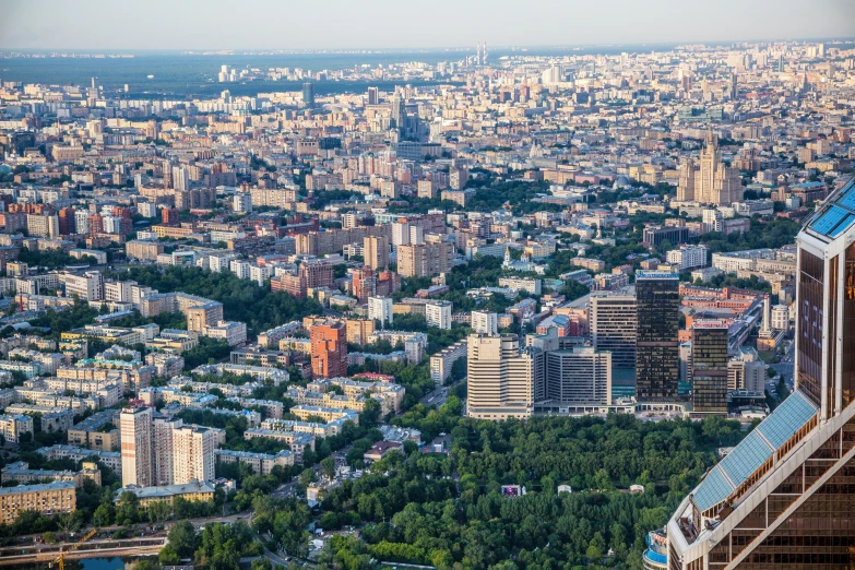 a view of a city from the top of a building, pexels contest winner, socialist realism, moscow, view from helicopter, city buildings on top of trees, фото девушка курит