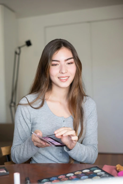 a woman sitting at a table in front of a laptop, holding a nintendo switch, portrait sophie mudd, high quality photo, asian face