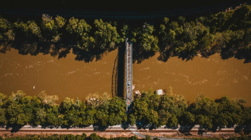 an aerial view of a bridge over a river, by Adam Marczyński, hurufiyya, “ iron bark, highly saturated, single flooded tower, cinematic shot ar 9:16 -n 6 -g